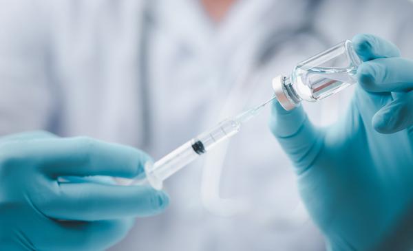 Vaccine syringe and vial is held in the hand (Source: LookerStudio/Shutterstock.com) (refer to: Seasonal Influenza Vaccines)