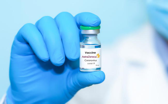 Vaccine ampoule is held in hand (Source: Stanislav Sukhin/Shutterstock.com)