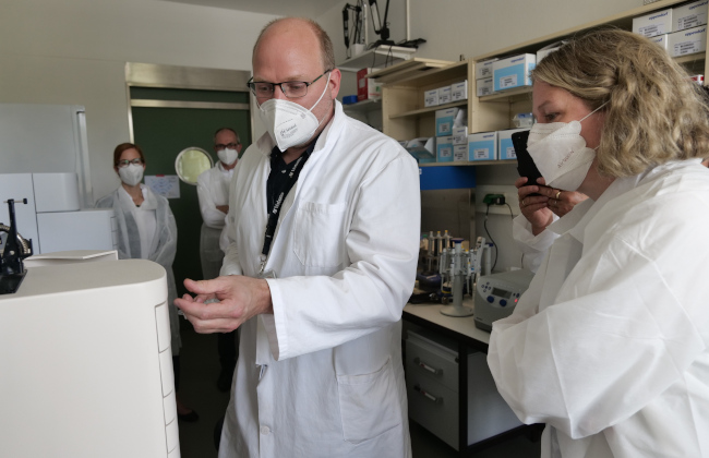 Dr Wolf Holtkamp demonstrates state secretary Dr Antje Draheim a testing method for the batch release of mRNA vaccines (Source: Morgenroth/Paul-Ehrlich-Institut).